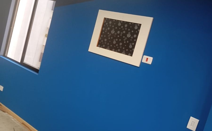 Sala com parede azul pintada e rodapé protegido