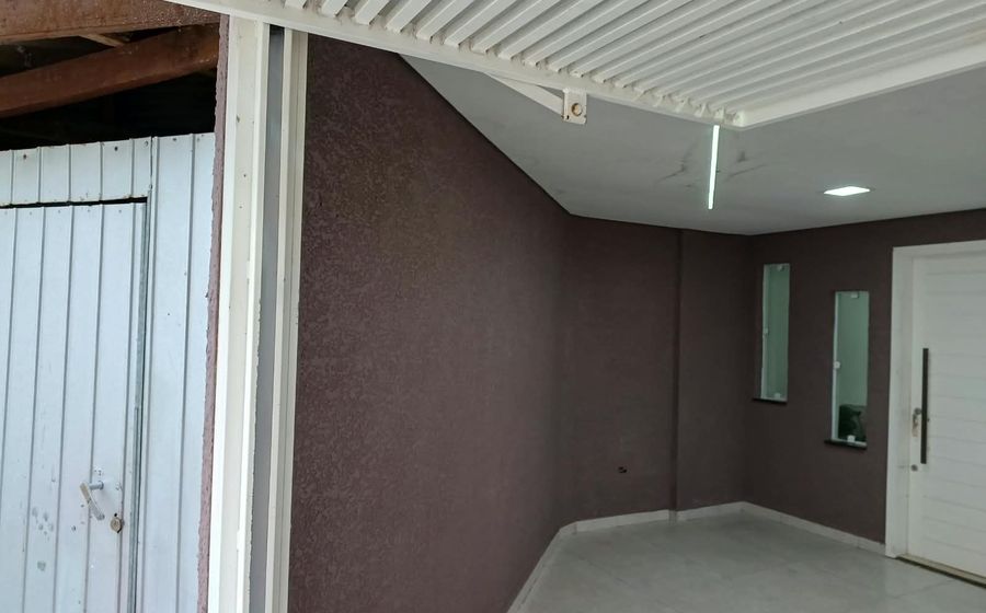 Área externa coberta com parede texturizada e porta branca