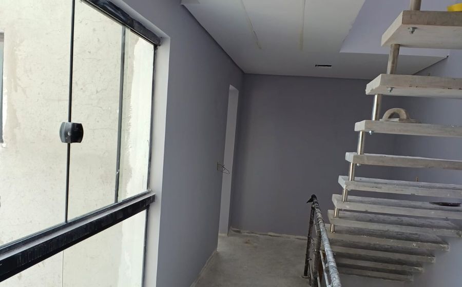 Corredor com escada e janelões de um imóvel de mais de um pavimento
